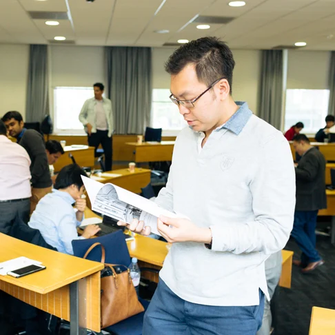 Man reading financial textbook in lecture theatre